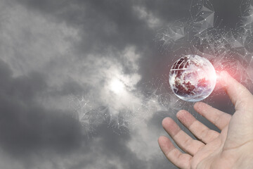 Hand reaching for a digital globe in cloudy sky.