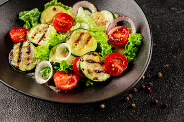 Salad grilled zucchini, tomato, lettuce tasty snack fresh delicious gourmet food background on the table rustic food top view copy space keto and paleo diet vegan and vegetarian food