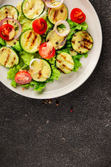 Salad grilled zucchini, tomato, lettuce tasty snack fresh delicious gourmet food background on the table rustic food top view copy space keto and paleo diet vegan and vegetarian food