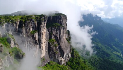 Dramatic cliffs piercing low clouds in a mountainous region landscape