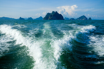 Motor yacht creates a stunning wake in Phang Nga Bay near Phuket, Thailand.