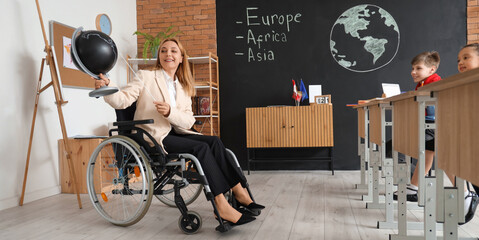 Mature teacher in wheelchair with pointer and globe conducting Geography lesson at school