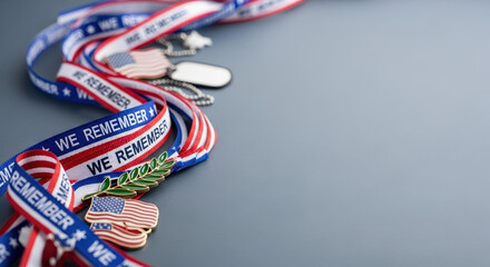 Patriotic memorial day accessories featuring ribbons and dog tags placed on gray backdrop. Patriotic memorial day elements include pin badges of American flag and laurel.