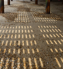 Shadow patterns on the beach under a Pier for use as a background texture