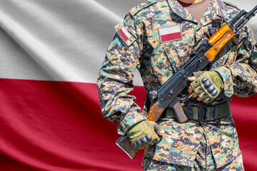 Fototapeta premium Poland flag with soldier in military uniform holding assault rifle in front of it
