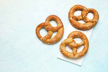 Tray and tasty pretzels on blue grunge background, closeup