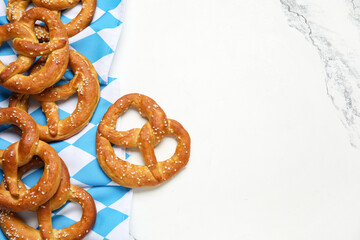 Napkin and tasty pretzels on marble background, closeup