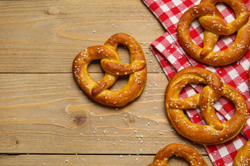 Napkin and tasty pretzels on wooden background, closeup