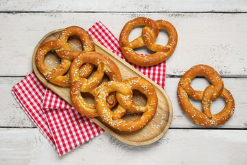 Tray with tasty pretzels on white wooden background, closeup
