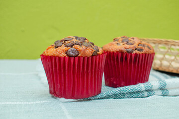 Dos pastelitos de chocolate en una mesa con mantel fris