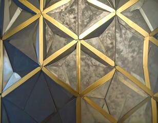 A geometric design featuring interlocking triangles of various shades of gray and accented with golden lines creates a captivating visual effect.
