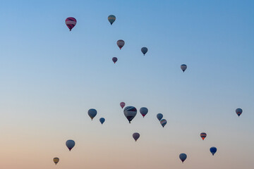 Hot air balloon flying over rocky landscape at sunrise in Cappadocia. Turkey