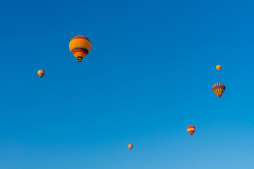 Three hot air balloons against a blue sky. Beautiful view of colourful hot air balloons from below. Cappadocia