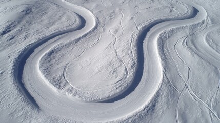 Aerial view of winding snow-covered trails in a serene winter landscape with soft sunlight