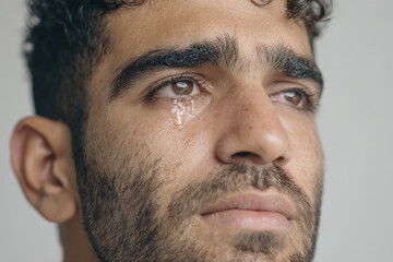 Obraz premium young man with tearstained cheeks expresses deep despair longing for hope and brighter future