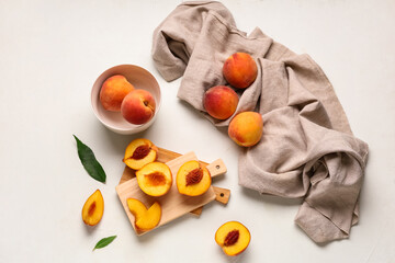 Wooden board and bowl with sweet ripe peaches on white background