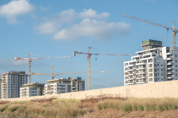 building is under construction, with a prominent crane towering over the site. The scene represents modern real estate development in Israel,  new arch housing  projects.
