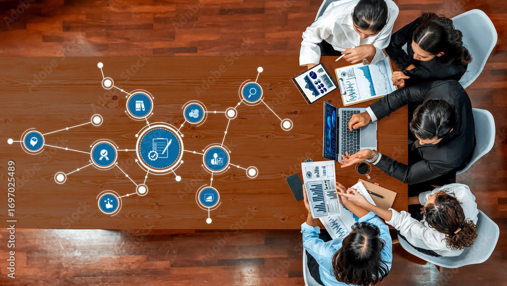 Poster a high-angle view of a business meeting with professionals engaged in discussion while analyzing dig