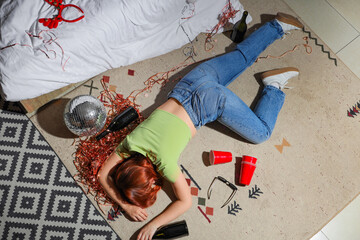 Drunk young woman sleeping on carpet in bedroom after party, top view