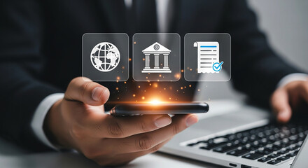 Person holding phone with globe bank and document icons above it near a laptop keyboard