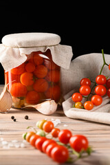 Rustic Still Life with Jar of Pickled Tomatoes and Fresh Cherry Tomatoes on Fabric