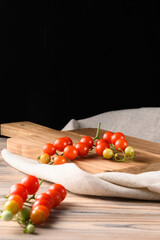 Cherry Tomatoes on Wooden Cutting Board with Natural Linen &ndash; Black Background