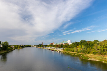 Fototapeta premium Magdeburg Elbe river embankment panoramic scenic view rv camper van motorhome parking camp church cathedral old cityscape dramatic blue sky. Riverside green city skyline historic tower urban building