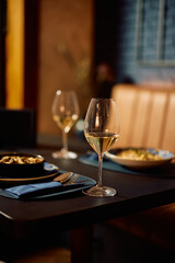 Table setting with a glass of white wine in restaurant.