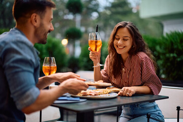 Happy woman enjoying in pizza with her boyfriend in restaurant.