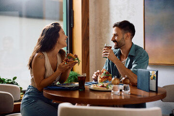Young couple enjoying in conversation while having lunch in pizzeria.