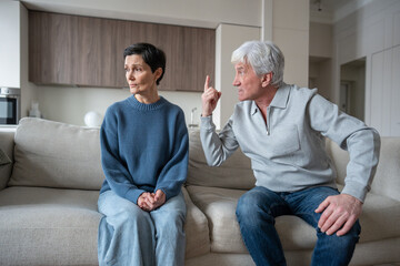 Marital discord in old couple. Shouting aggressive husband arguing with scared wife at home,...