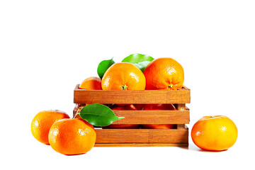 Juicy shiny tangerines with leaves in a wooden crate isolated on a white background.