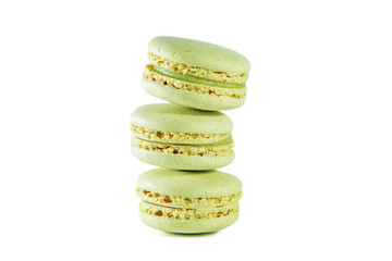 Three green pistachio macaroons isolated on white background.