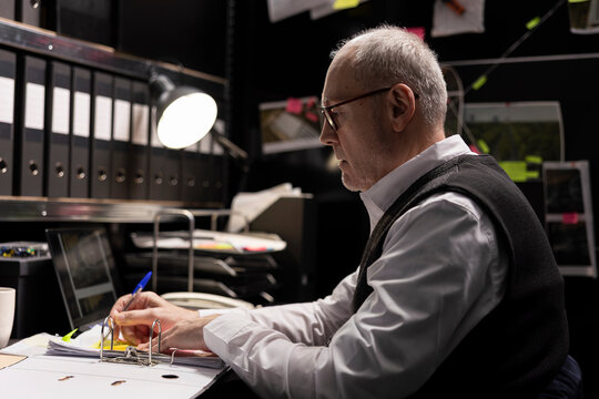 Chief of police inspector evaluates confidential case files and suspect profiles, analyzing records and linking evidence for law enforcement criminal investigation. Forensic clues.