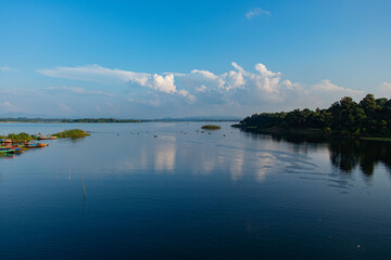 Idyllic lakeside scene at Kaptai with calm blue water, anchored boats, and a panoramic view of nature.