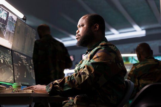 Counterterrorism division operative using target acquisition technology to detect enemy location. African american defense security agent using satellite equipment to track threats