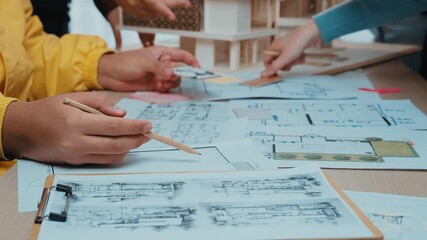Close-up of hands actively planning architectural layouts during a creative workshop, showcasing sketches, notes, and collaboration in a vibrant workspace. SACTR