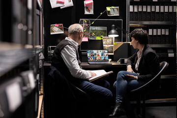 Experts agents conduct detective work over a teleconference in evidence room, sharing intelligence and discussing clues for a confidential case files to uncover information about a crime.