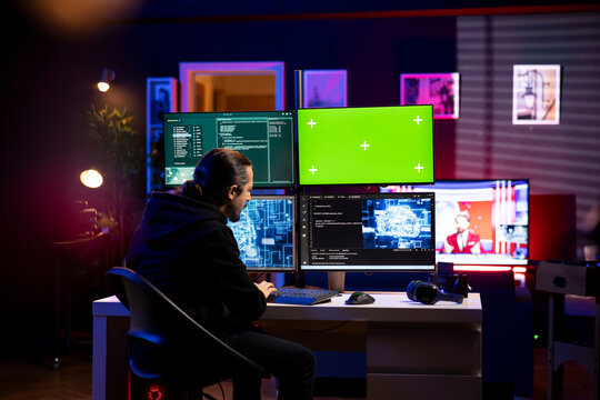 Hacker runs neural network program on green screen mockup PC to breach company security and open locked databases. Man doing cyber attacks using deep learning technology on chroma key PC - Powered by Adobe