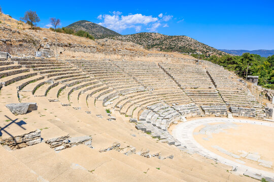 A large stone amphitheater with a stage and a few benches. Ruins of the ancient city of Philippi, Greece