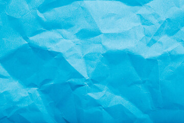 Obraz premium Textured blue paper background with geometric creases and crumples