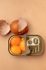 Raw egg yolks and forks in an open can on a pastel green plate. Modernist idea