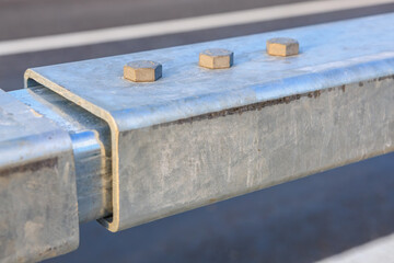 Metal guardrail close-up with nuts and bolts on highway
