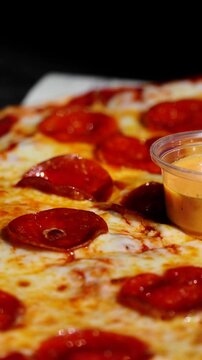 Pizza de pepperoni reci&eacute;n horneada servida en tabla de madera
