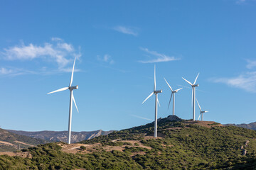 Wind turbines on green hills under blue sky. Gibraltar, spain. september 2025.