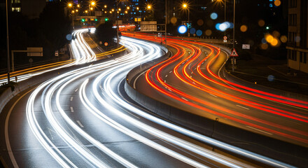 Long-exposure shot of a highway at night, capturing light trails from moving vehicles. Emphasizing speed and the constant movement of city life.