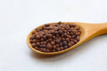 Brown dried allspice spice seeds.