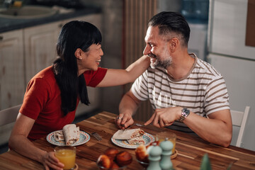 Happy couple enjoying breakfast together at home