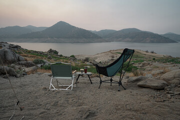 キャンプ場の朝焼けを見ながらコーヒーを飲む