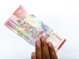 Obraz premium Broken and dirty Rupiah paper money on a white background. Conceptual photo of old dirty crumpled Indonesian Rupiah, illustrating criminal money, dirty money. Crumpled wrinkled money paper. Rp 75000